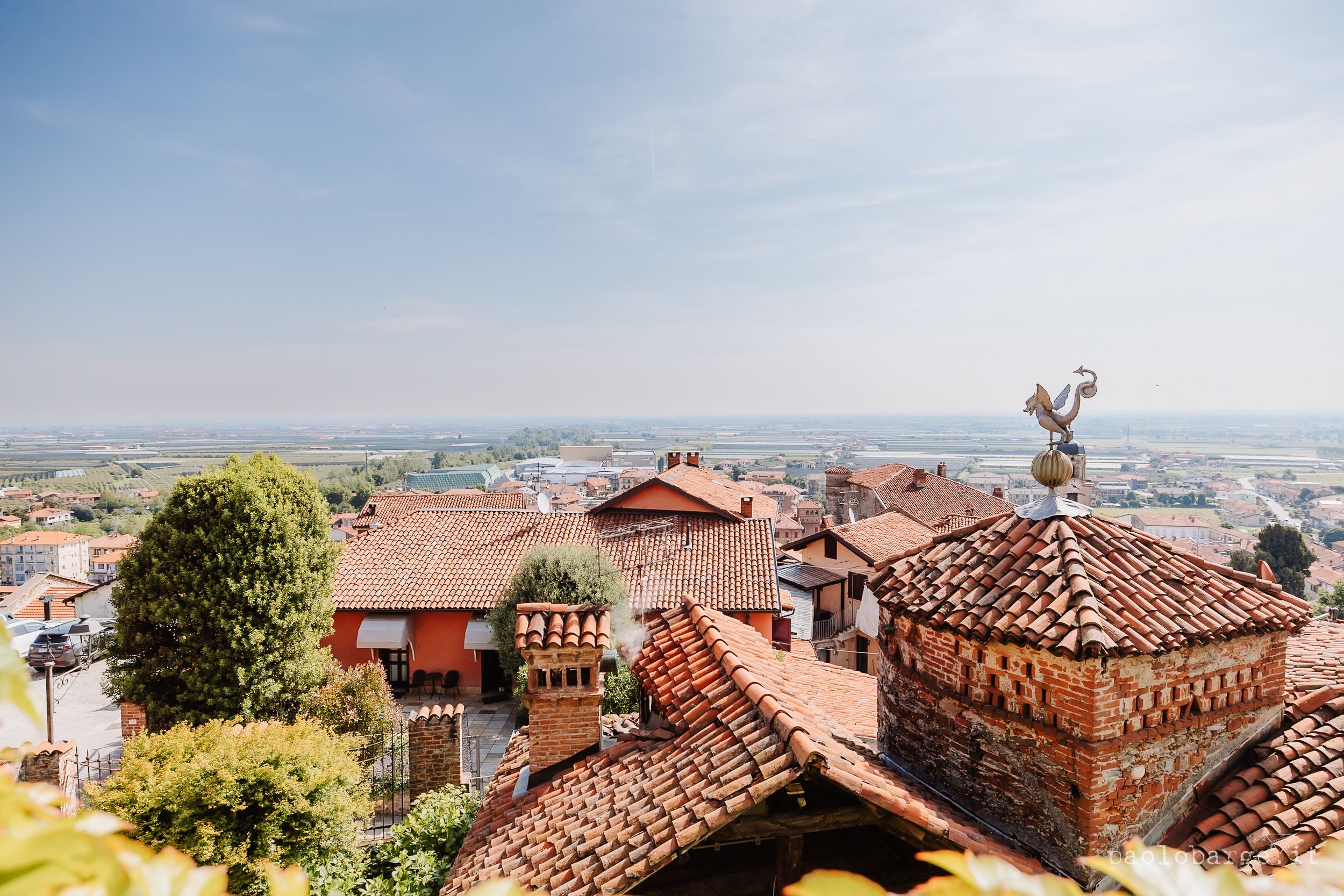 Panoramic view of terracotta rooftops and historic buildings in a hillside Mediterranean town.