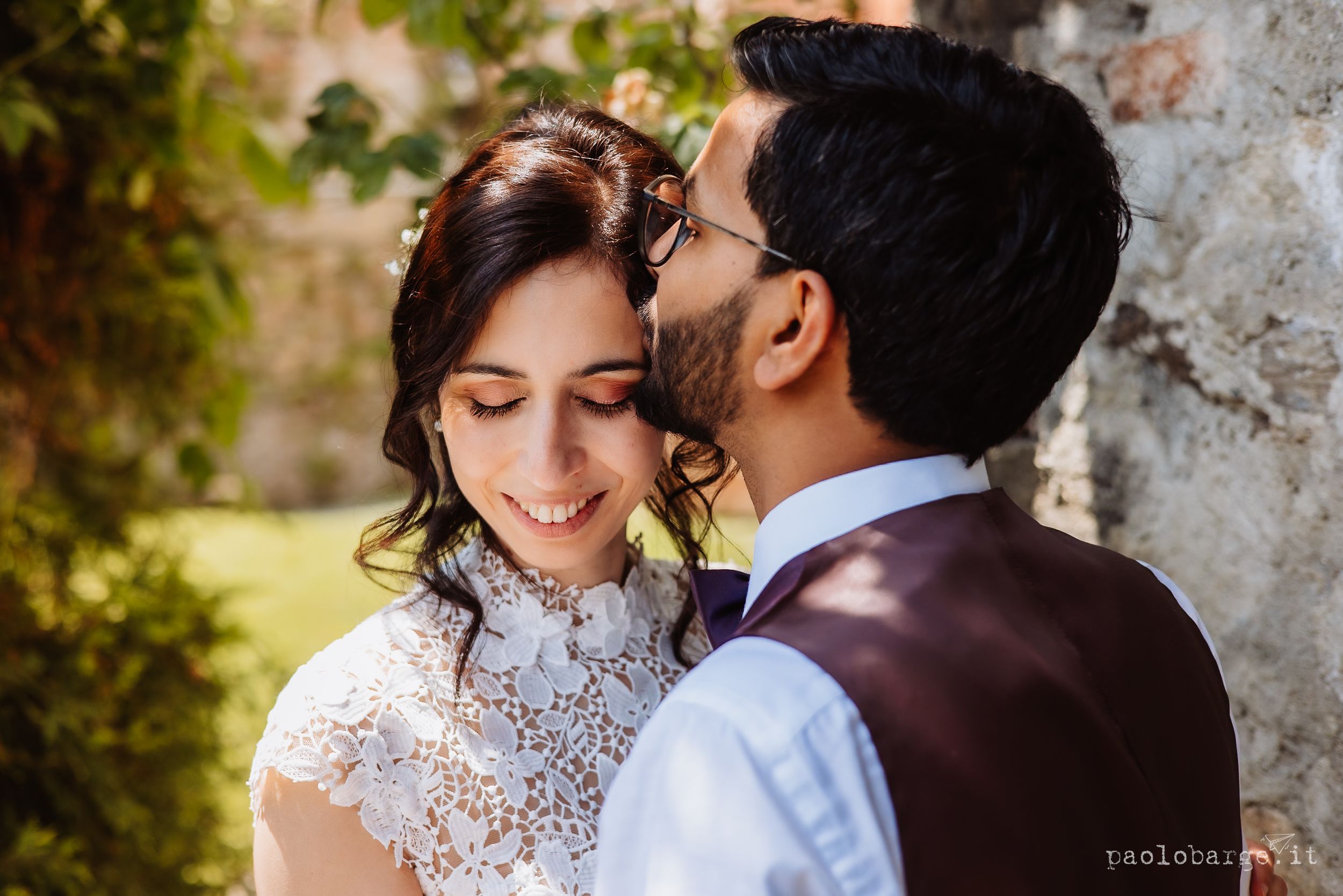 Romantic couple in formal wedding attire sharing tender moments during outdoor autumn photoshoot in natural setting.