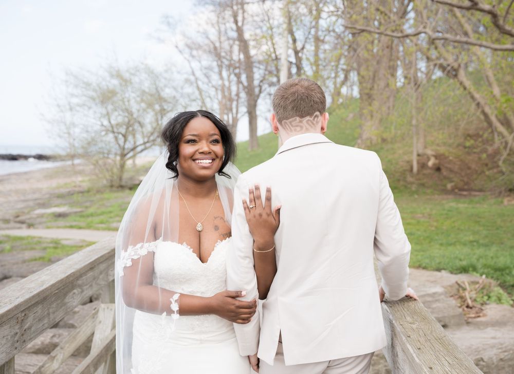 Wedding couple celebrates on a wooden boardwalk surrounded by nature in springtime.