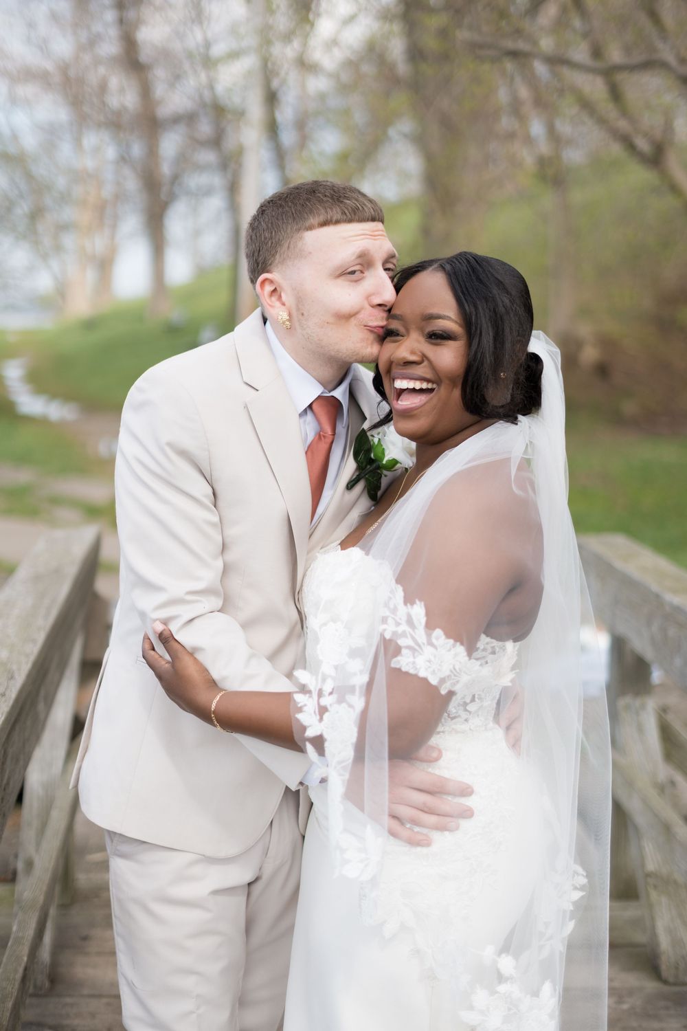 Joyful newlyweds share tender moments in a series of romantic outdoor wedding portraits along a rustic wooden bridge.