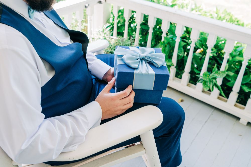 Two people in business attire review documents together on a balcony with white railings.