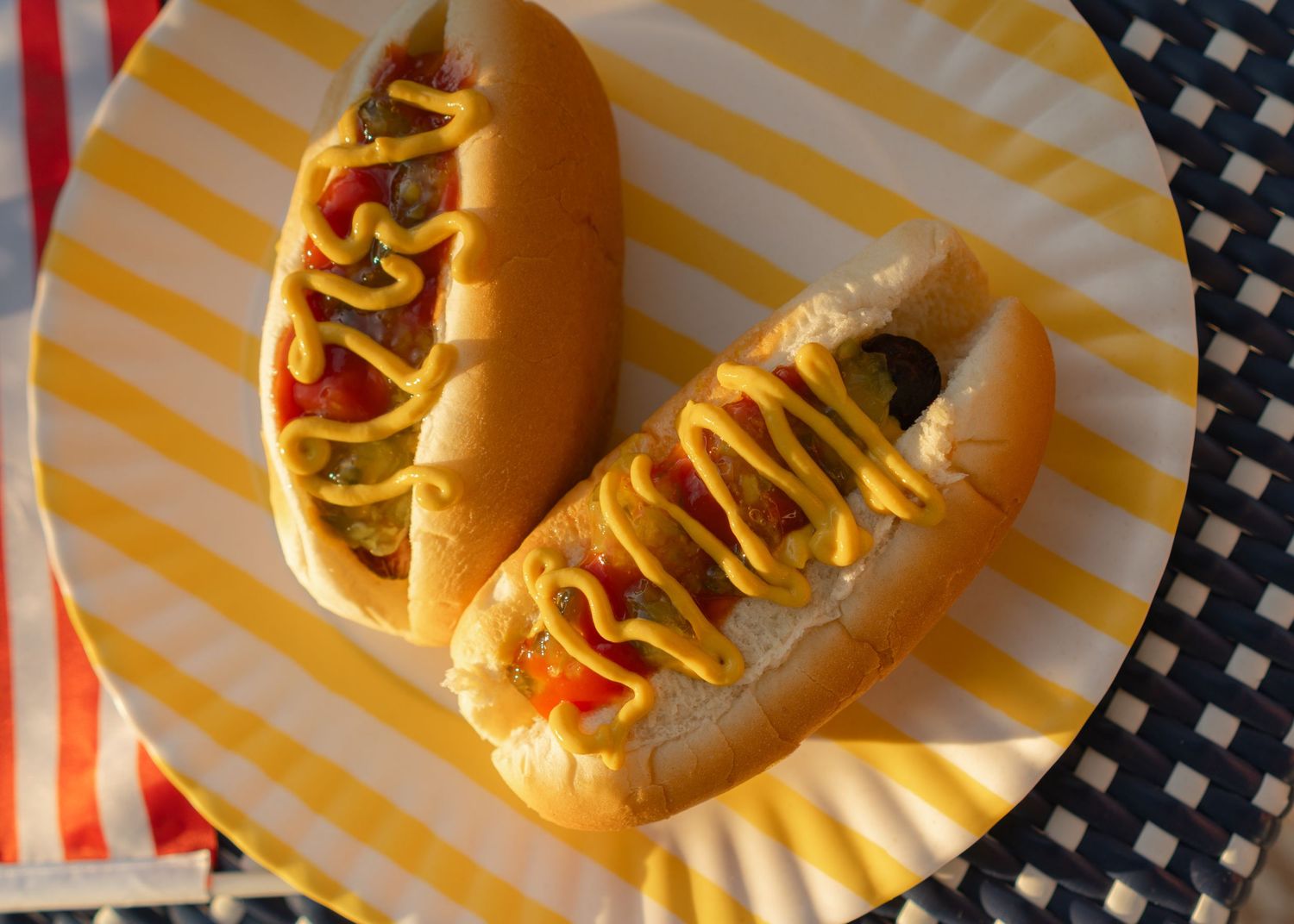 Two hot dogs dressed with mustard