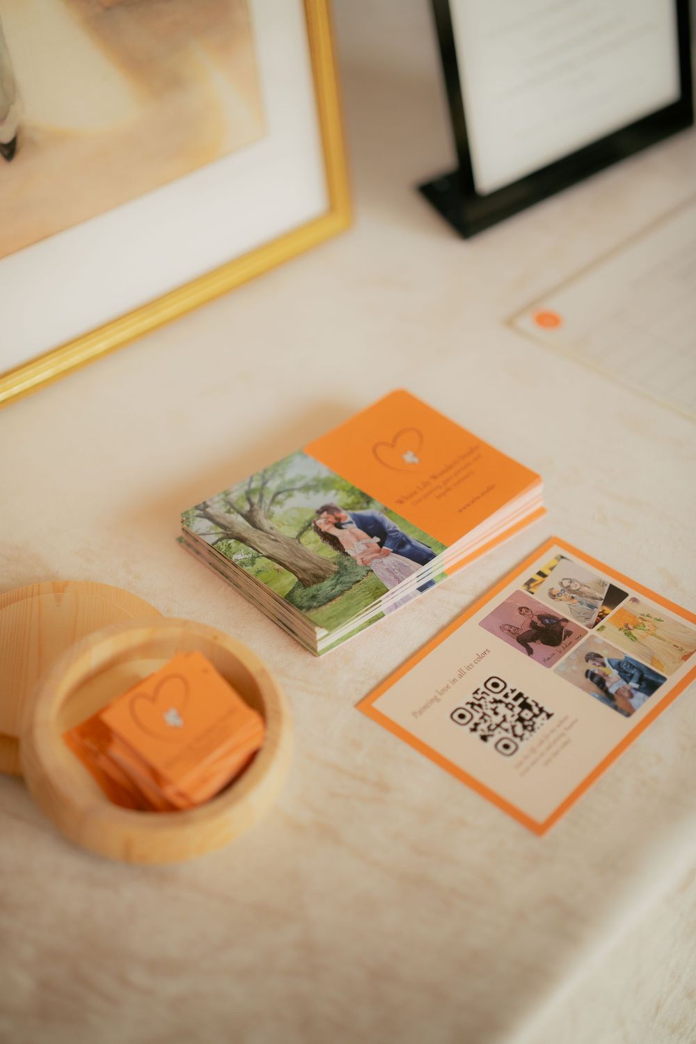 Orange-themed marketing materials and business cards arranged on a light colored surface with printed photos.
