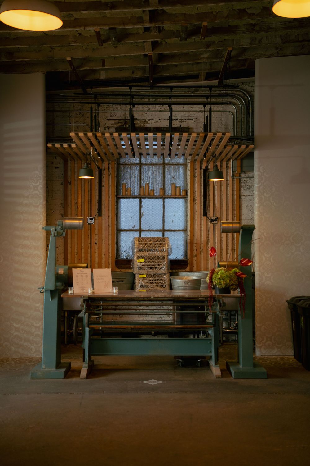 Rustic wooden entryway with industrial lighting features decorative slat design and vintage workbench in warm ambient setting.
