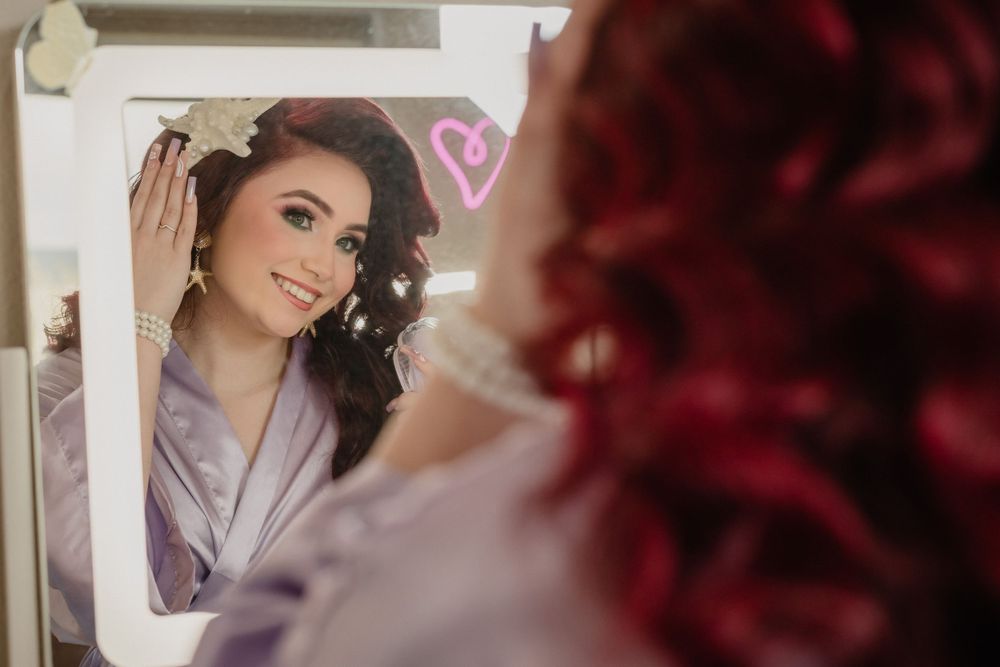 Mirror reflection captures person in purple robe during a glamour photoshoot.