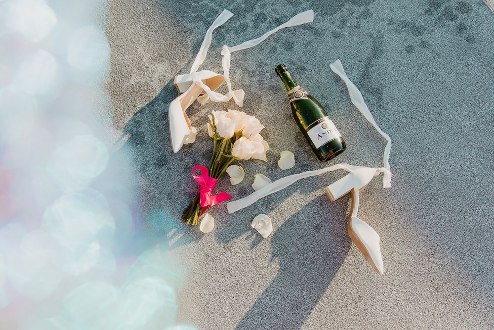 Wedding details including champagne bottle and ribbons laid out on a beach in Louisville, Kentucky.
