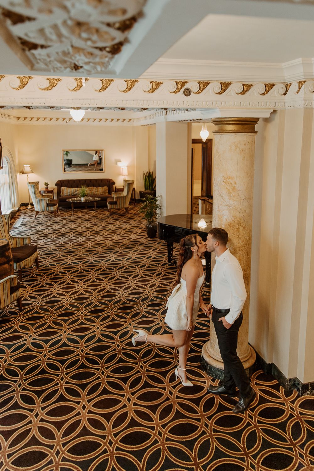 Couple sharing an intimate moment on a geometric patterned carpet in a luxurious hallway in Louisville, Kentucky.