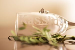 Personalized glass with 'Kassidy' etched on it, surrounded by delicate greenery.