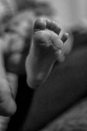 Close-up black and white photograph of a tiny baby foot.