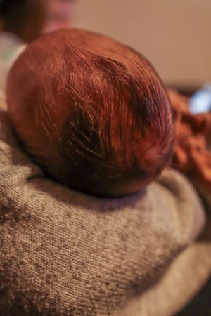 Artistic close-up photo of a baby's head with warm lighting and soft focus.