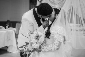 An intimate black and white portrait of newlyweds sharing tender moment at their wedding.