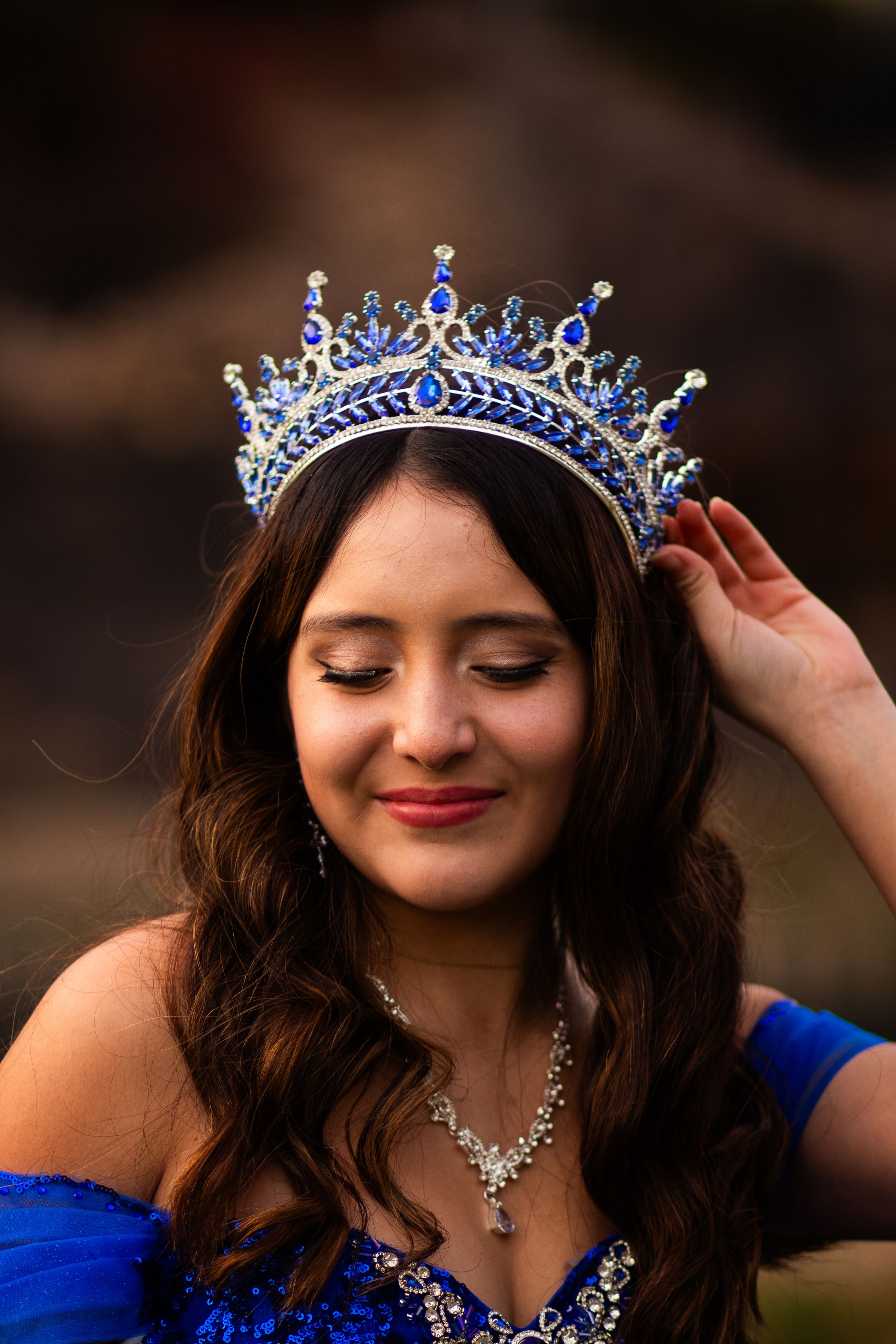 Ornate blue and silver tiara crowns formal portrait with matching jewelry.