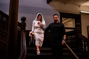 A bride and groom descend a staircase together during their wedding celebration.