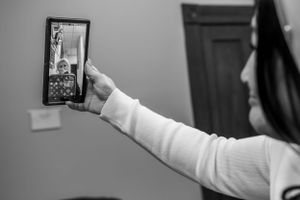 Someone taking a selfie in a mirror while wearing a white sweater.