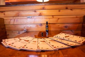 A wooden table displays a collection of light colored playing cards arranged in a circular pattern.