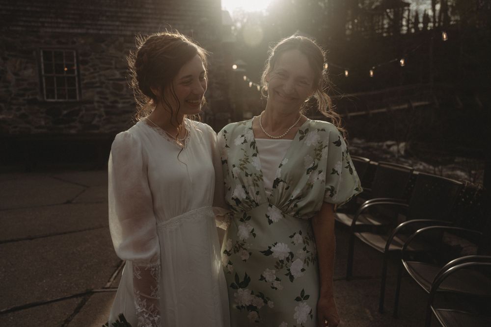 Two attendees share a candid moment at an evening wedding reception.