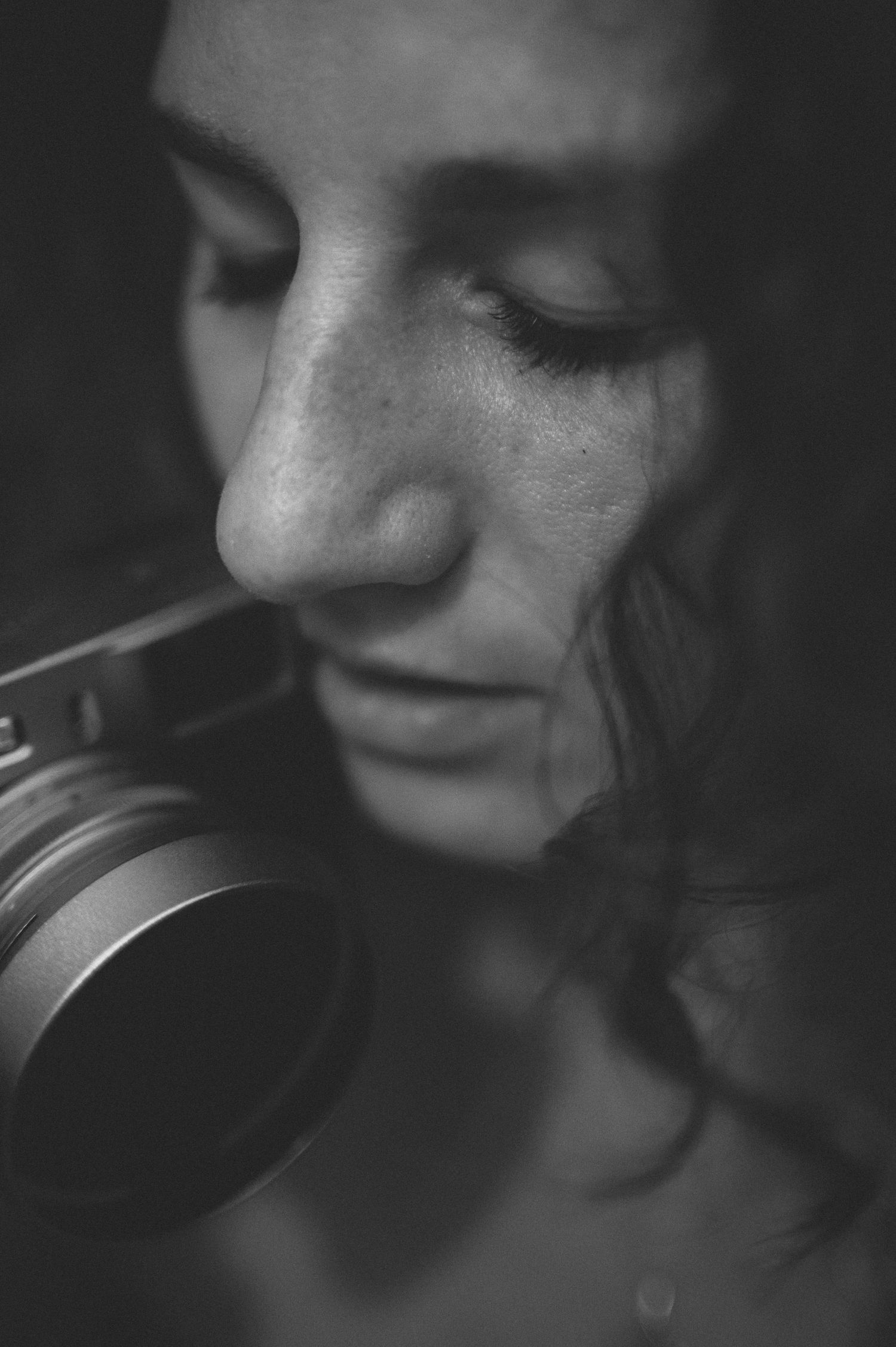 Black and white portrait of photographer holding vintage camera.