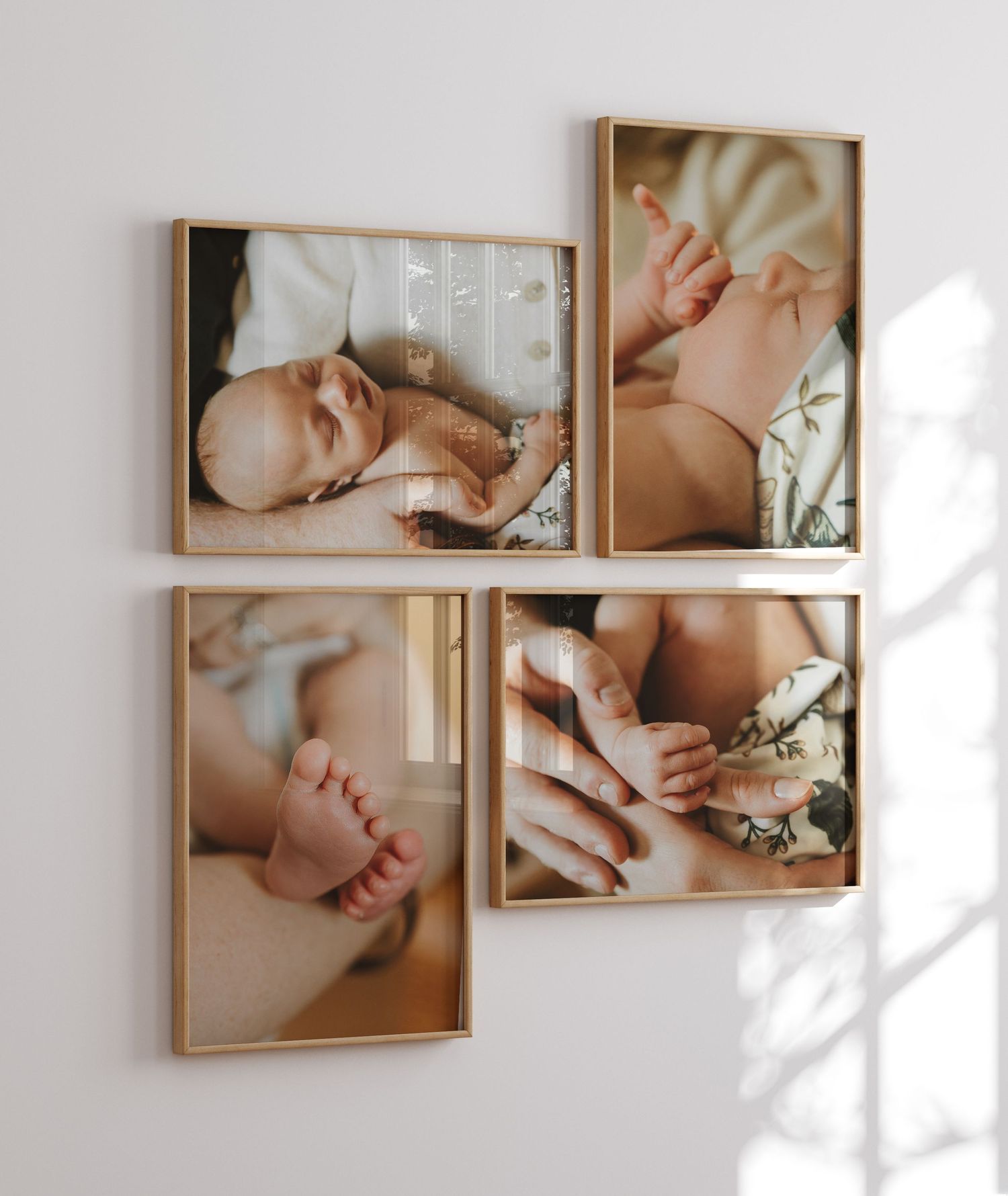 Four framed sepia-toned newborn photographs arranged on a wall showcasing delicate moments and tiny details.