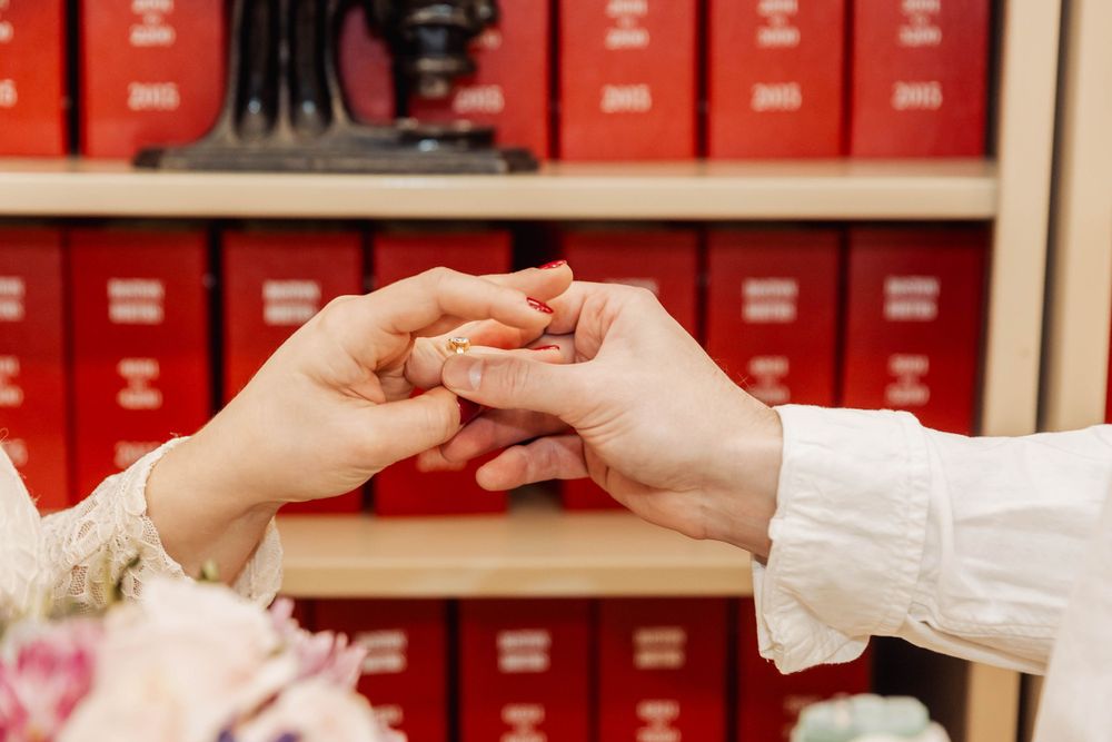 Close up of hands exchanging rings during intimate ceremony.