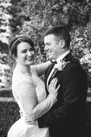 A black and white candid wedding portrait capturing laughter and joy.