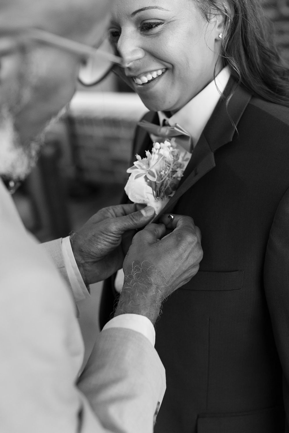 Black and white photo sequence captures multiple angles of a romantic corsage pinning moment at formal event.