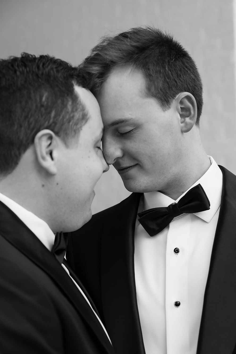 Two figures in formal black and white attire share an intimate artistic portrait sequence.