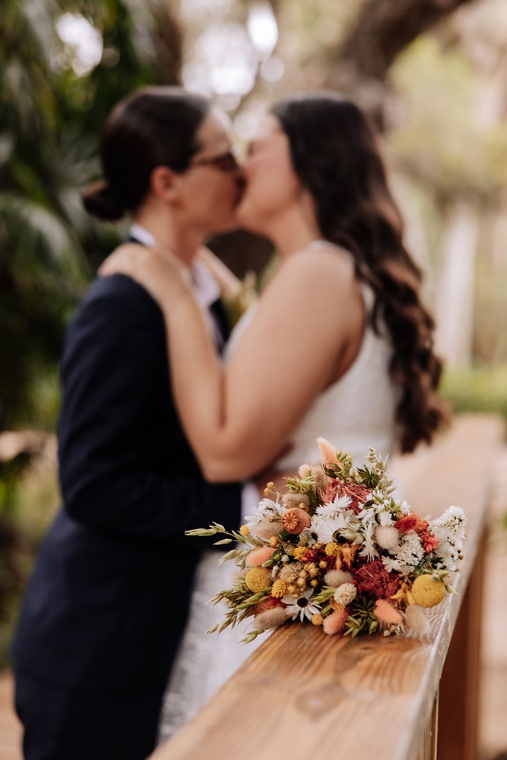 A romantic wedding moment captured in various angles with bright autumn-colored floral bouquet in focus.