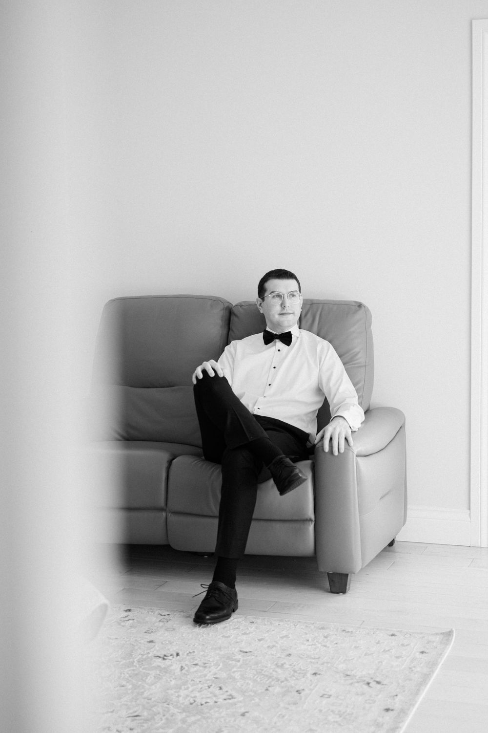 Formal portrait in black and white showing person seated in leather chair.