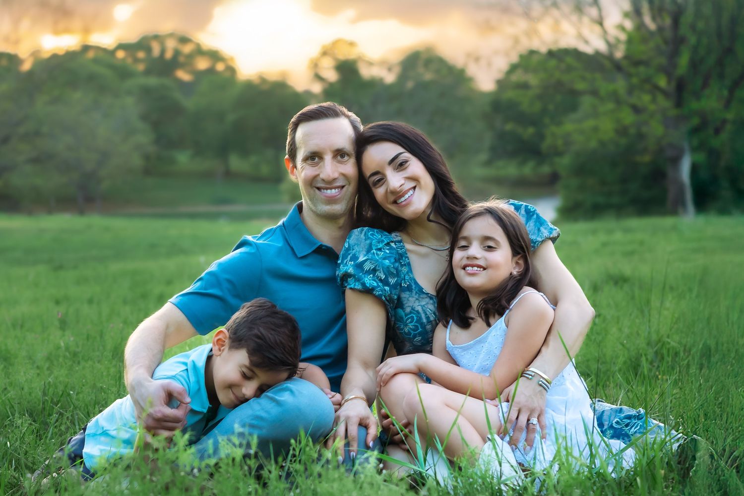 Family of four smile and cuddle in tall grass during a family session in Athens, GA - Athens, Watkinsville & Bogart family photographer