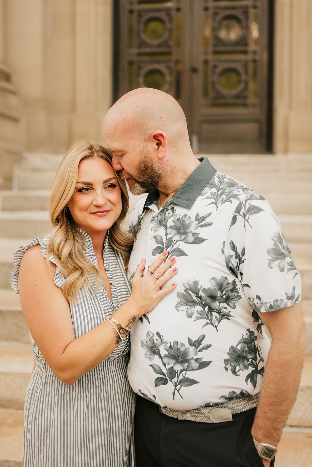 husband sweetly nuzzles wife as she looks off in the distance