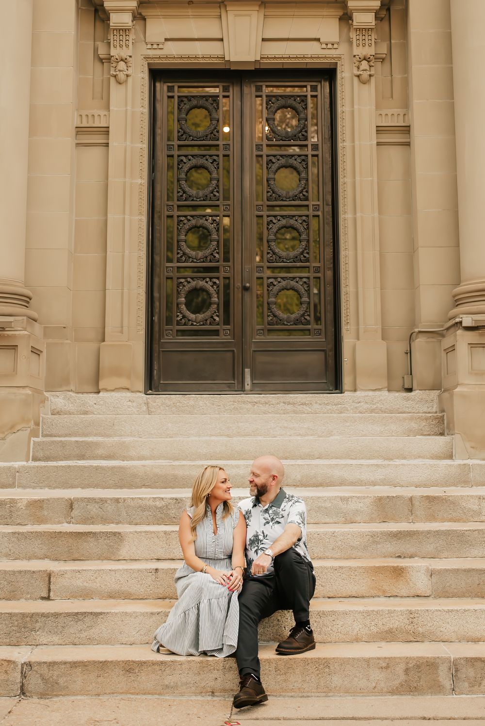 husband and wife cuddle up on the steps of over the Rhine building near Washington park in cincinnati, ohio