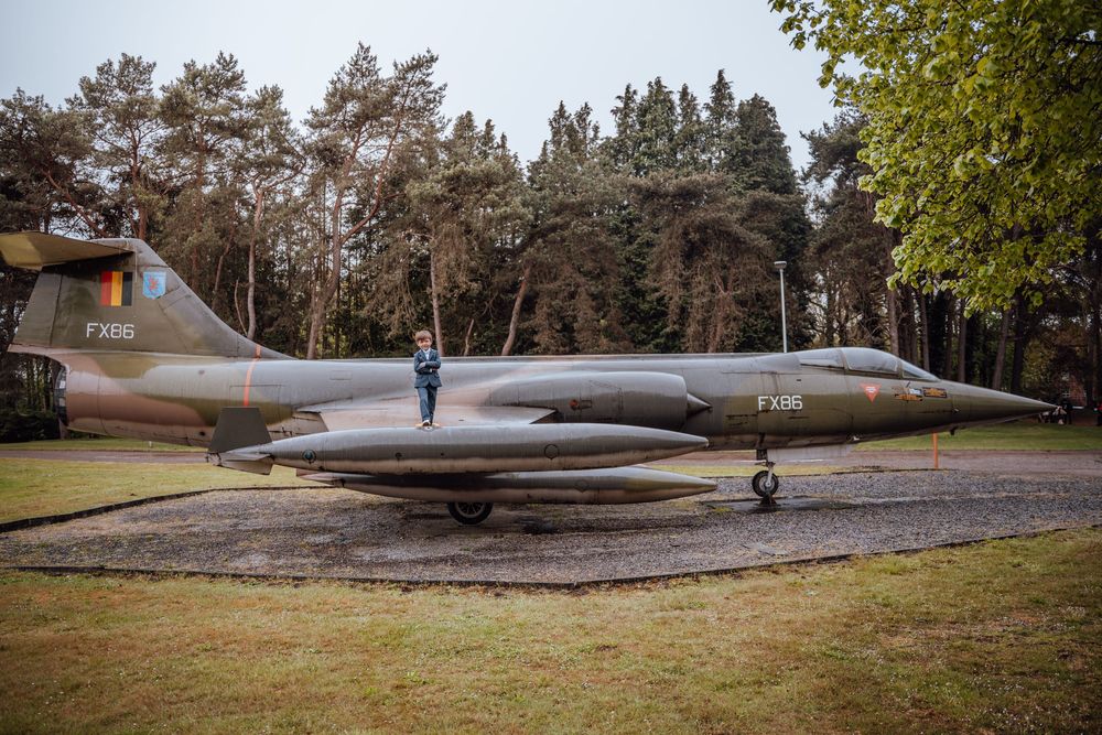 Een oud militair Mirage-gevechtsvliegtuig buiten in een bos op een bewolkte dag.