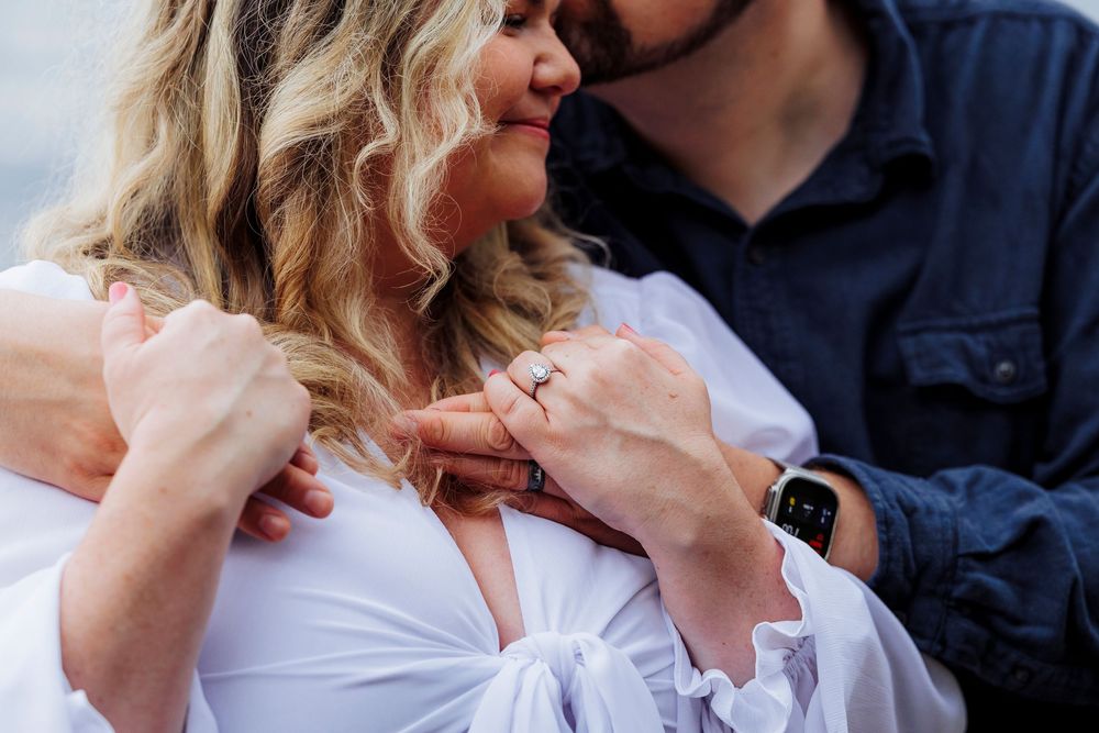 Romantic close-up of couple sharing an intimate moment together, with woman in white top and partner in navy blue.