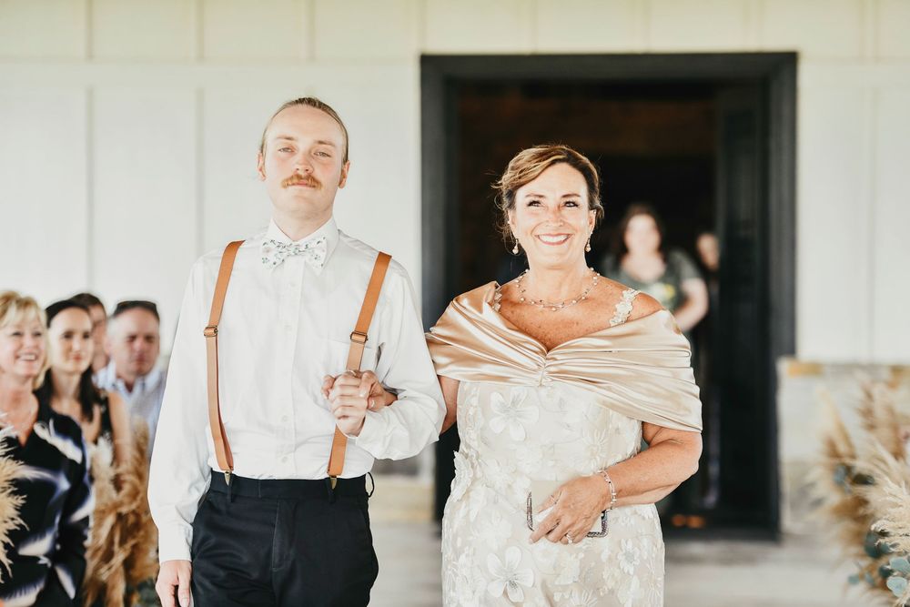 mother of the bride walks down the aisle