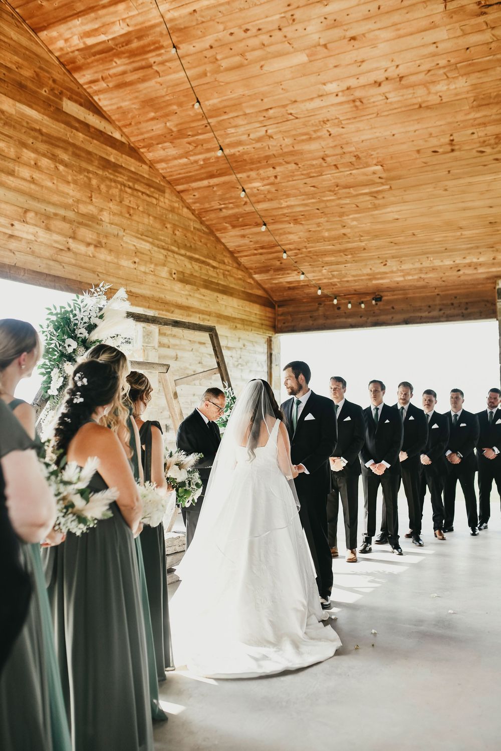 Bride and groom recessional under rustic pavilion at The Madelyn