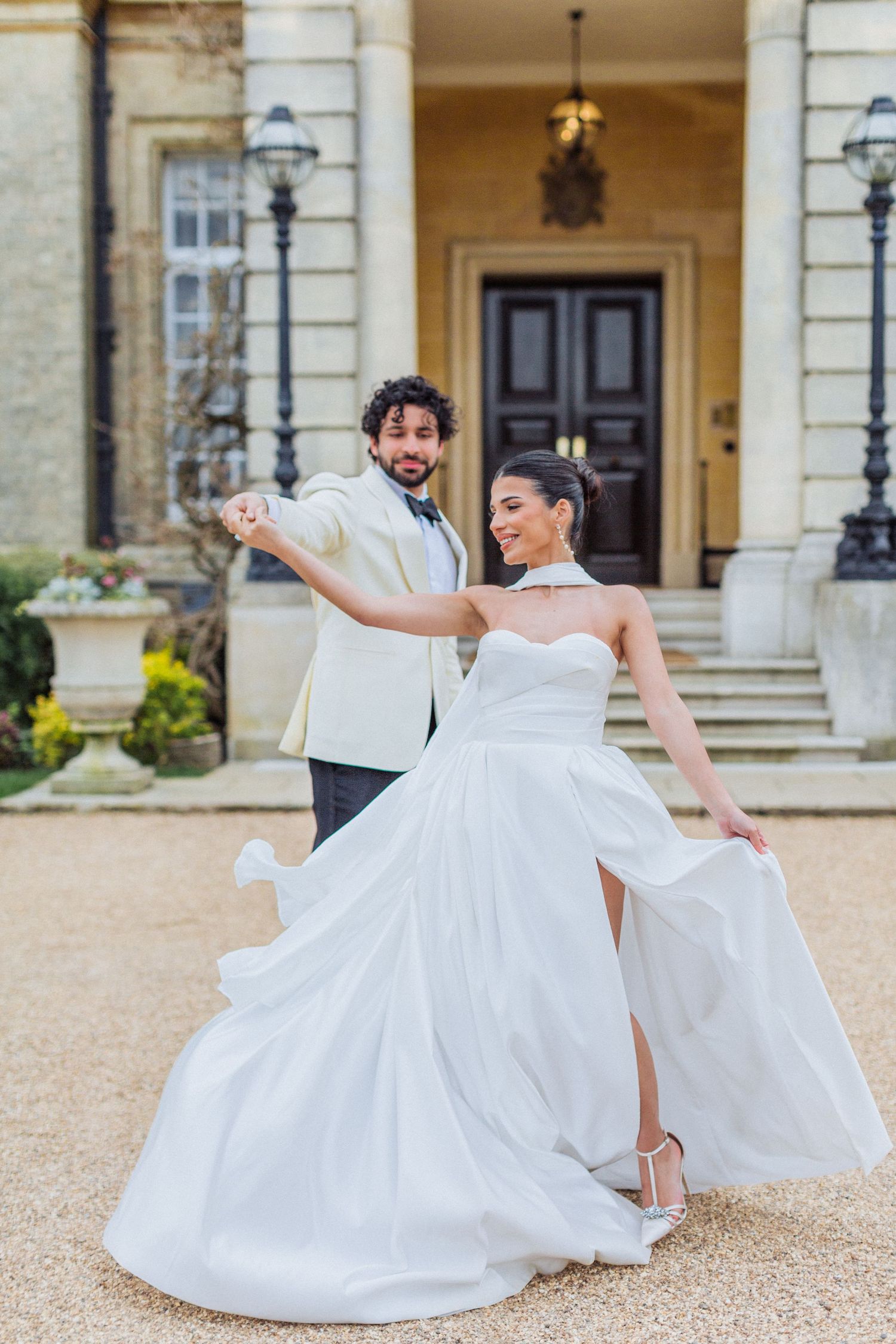 A couple dances outside an elegant mansion Hedsor House with white columns, Mara Marie dress by Hayley Elizabeth photography