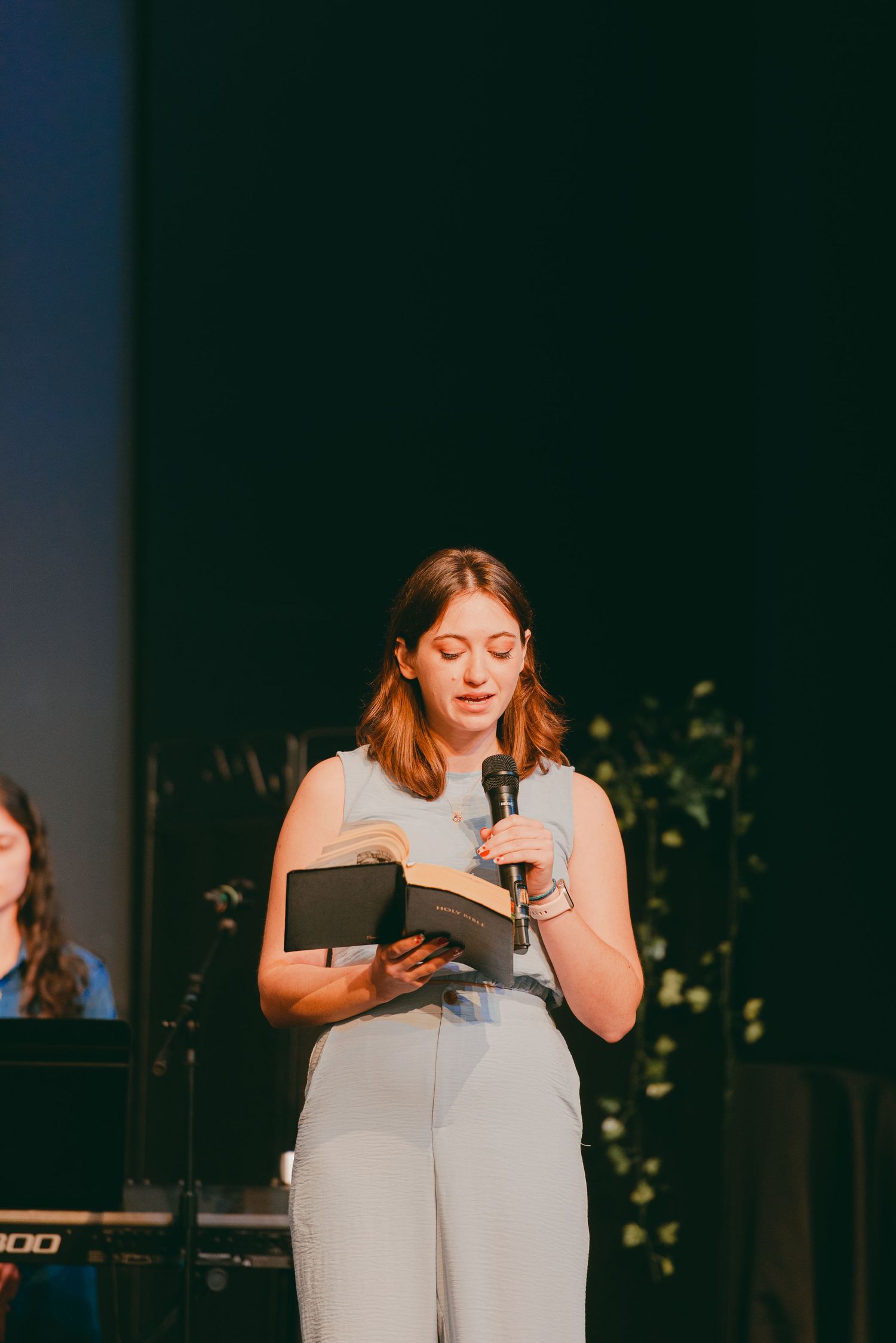 Sister of bride reading a Bible passage at church wedding reception