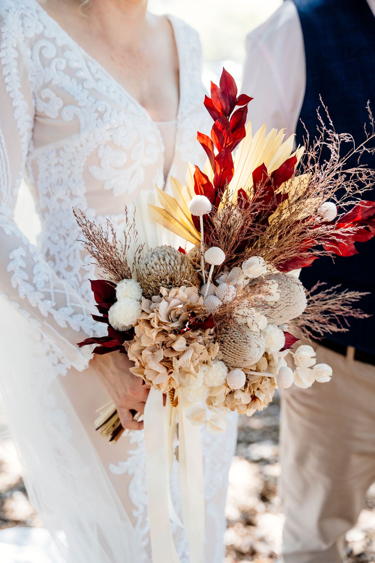 Intimate rooftop wedding ceremony overlooking a modern city skyline with white floral arrangements and white chairs.