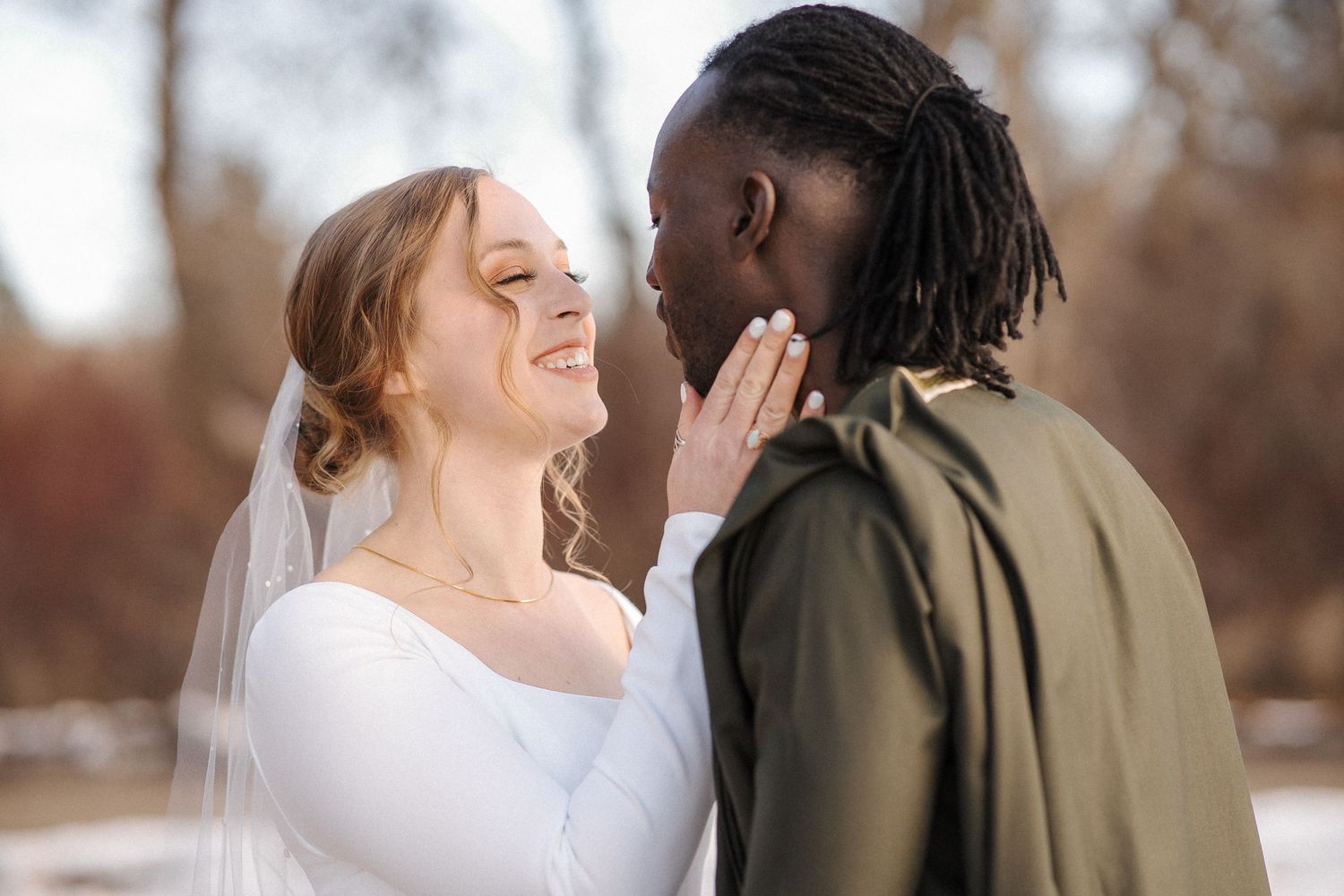 Happy couple shares an intimate moment outdoors while celebrating their wedding day in autumn.
