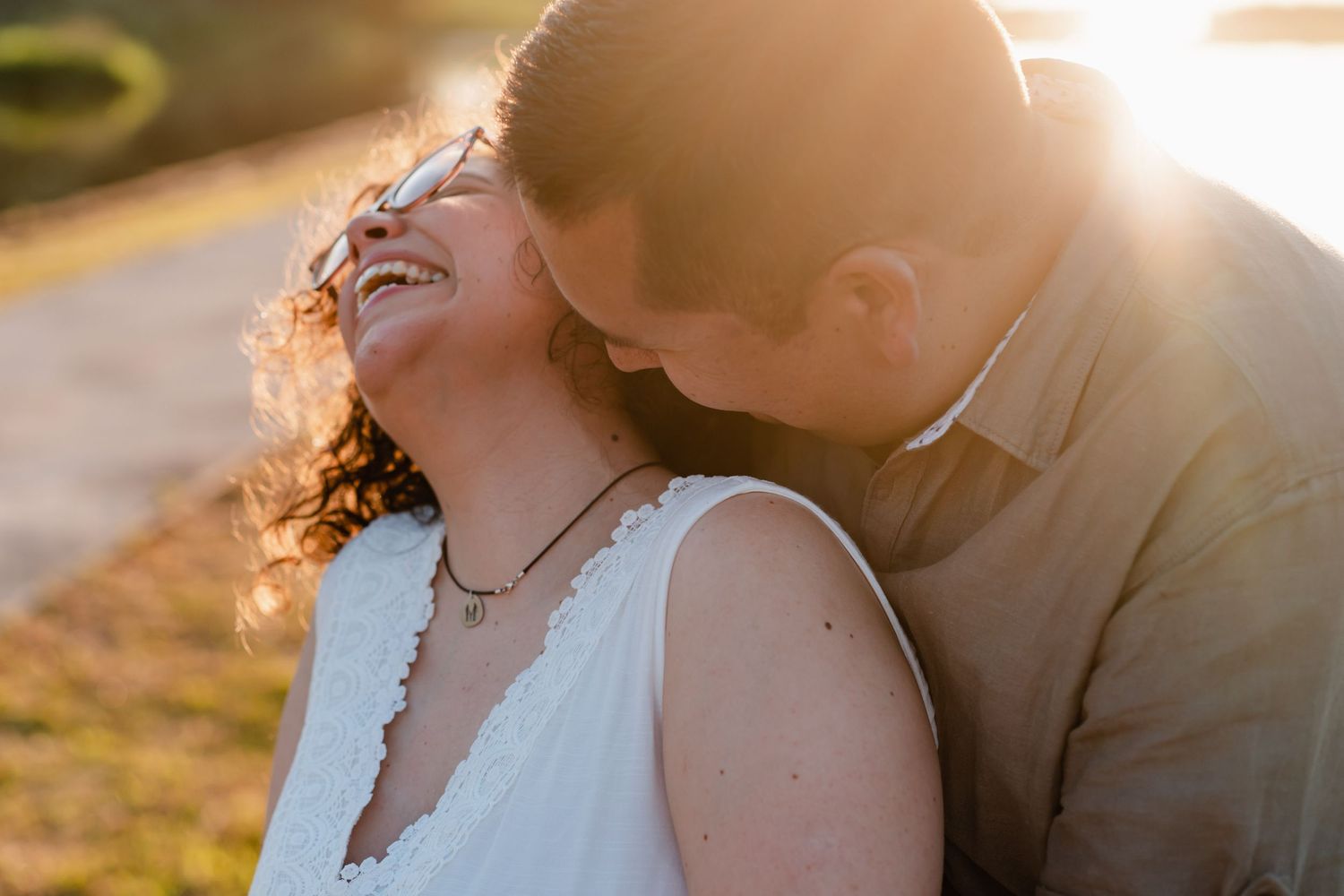 Happy couple embracing outdoors during golden hour sunlight.
