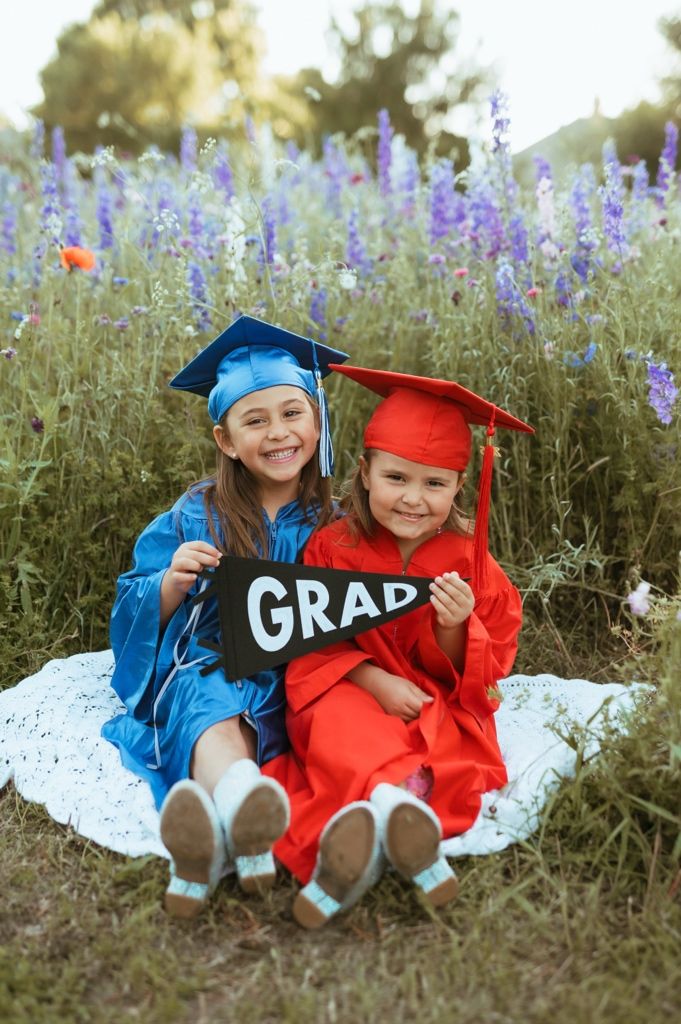 Graduation portrait series showing students in red and blue caps and gowns laying in purple wildflowers.