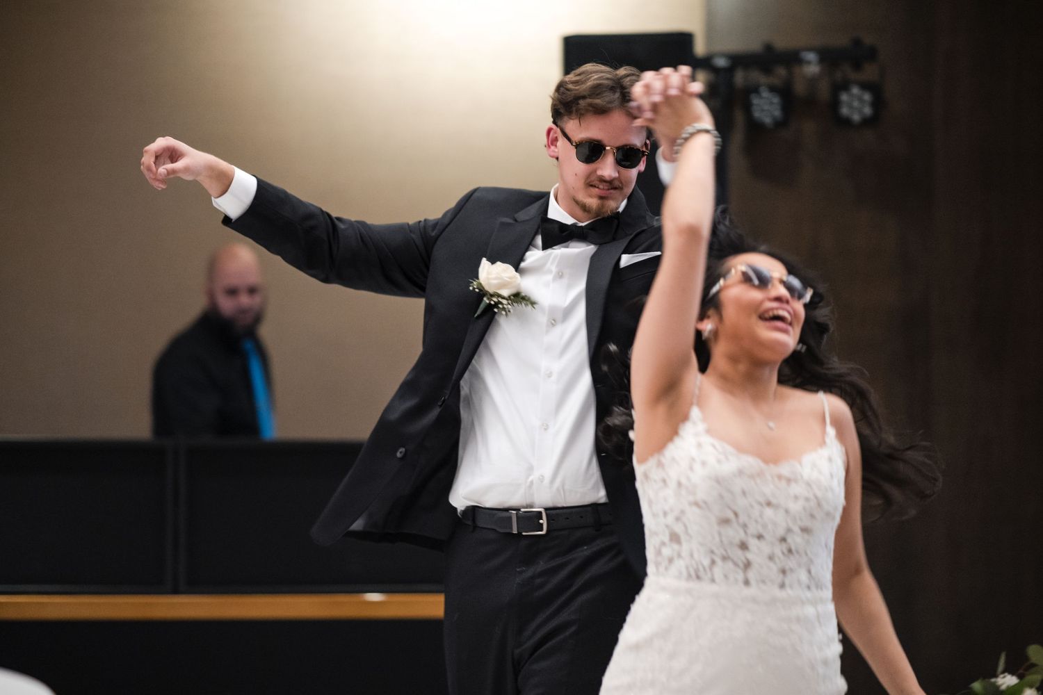 Newlyweds dance energetically during their wedding reception.