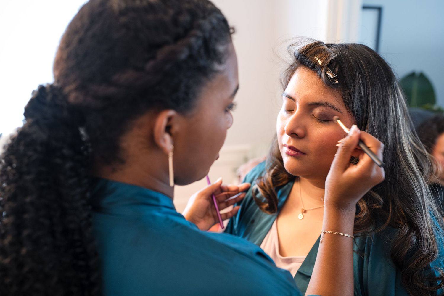 Makeup artist applying cosmetics to a client during a beauty session.
