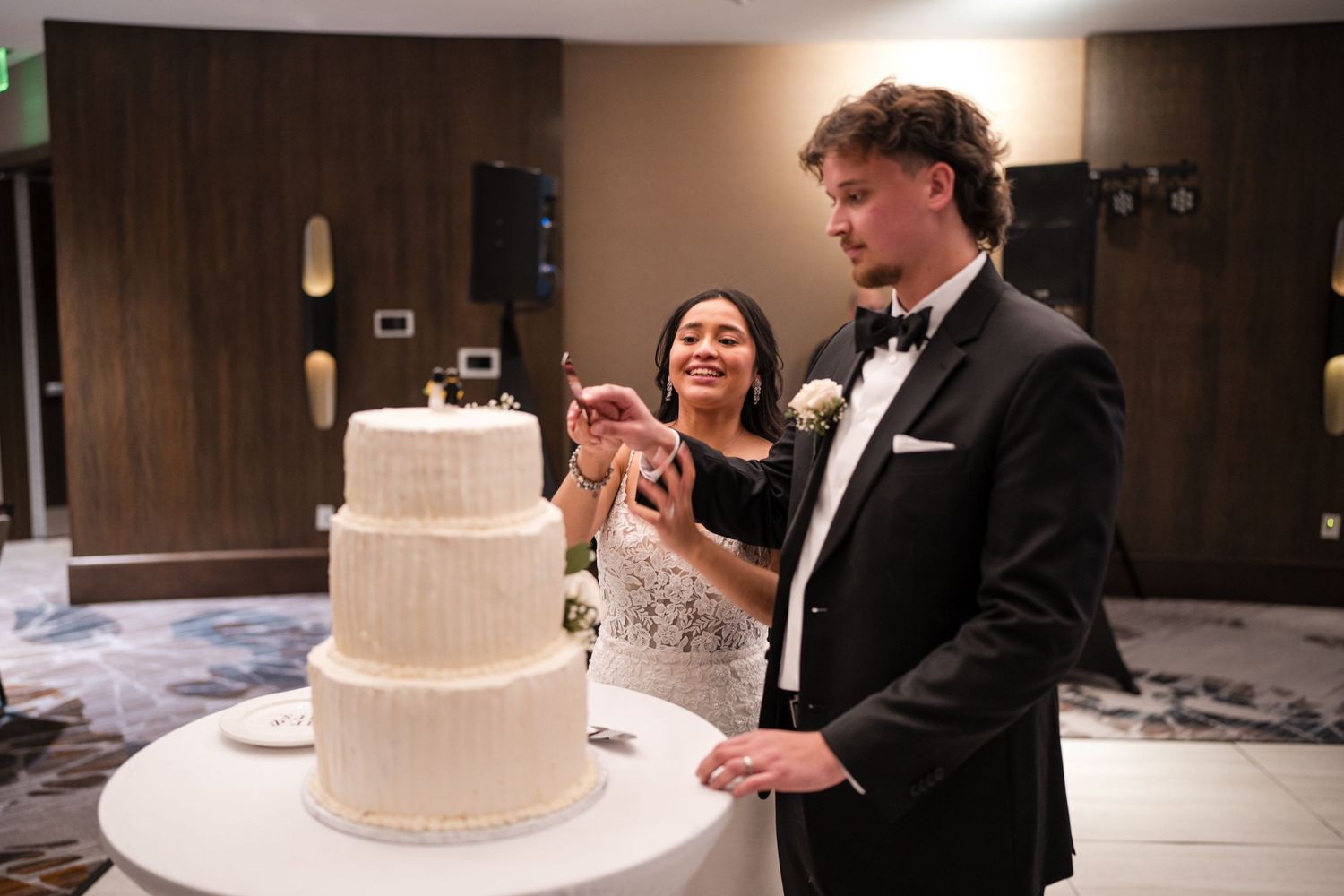 Happy couple enjoys their first cake cutting moment at their wedding reception.