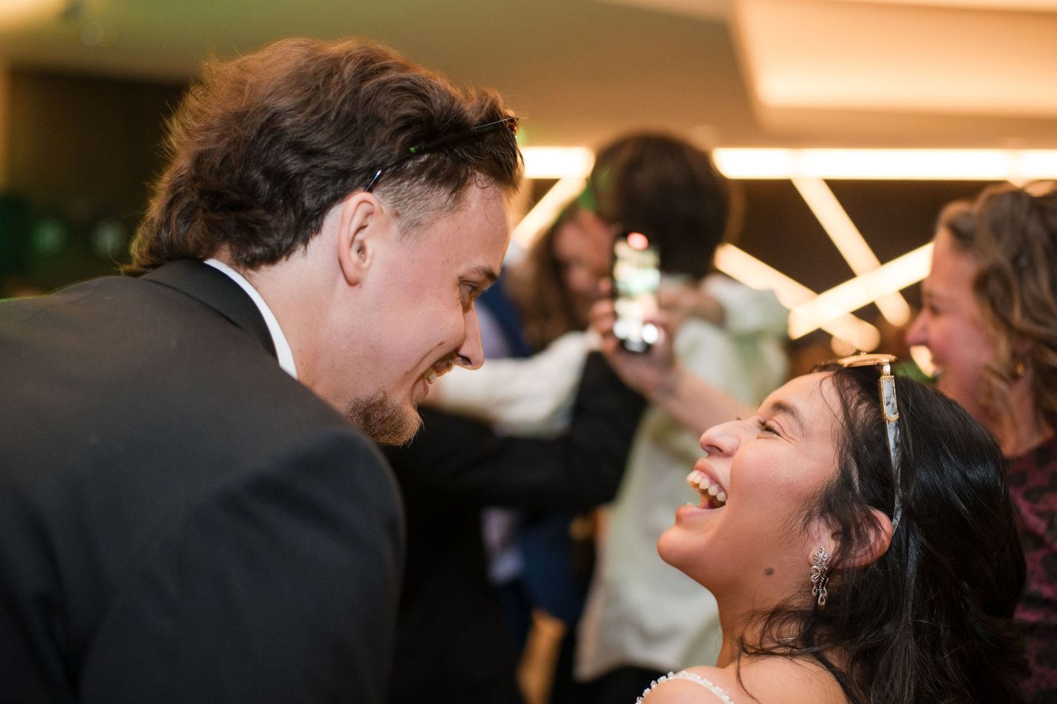 Candid moment of guests sharing laughter during evening celebration.