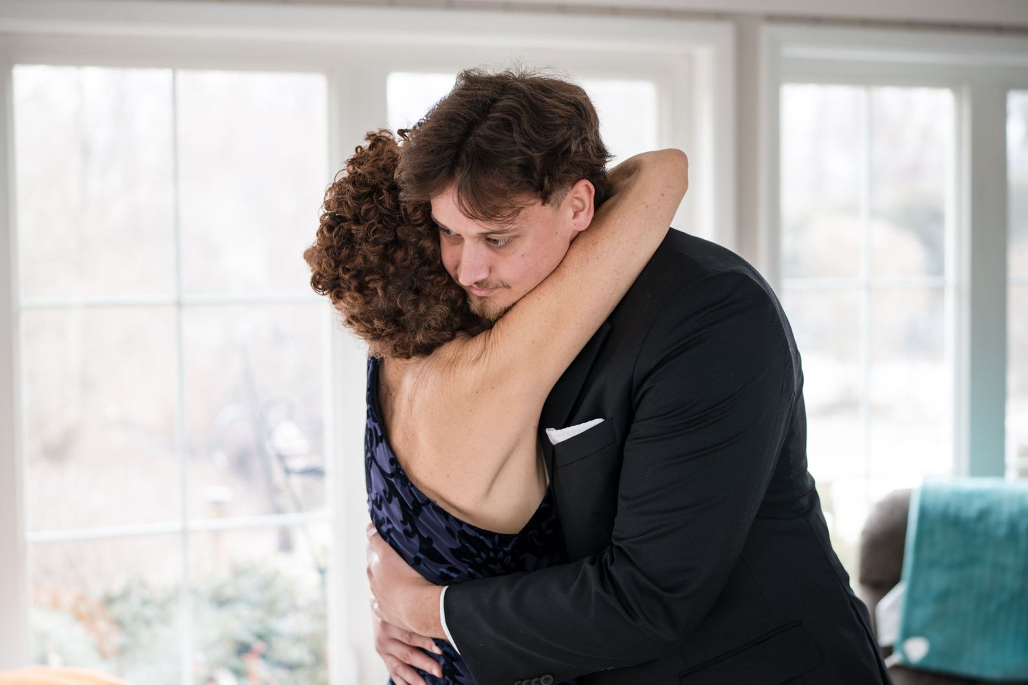 A tender embrace between two people at a formal event.