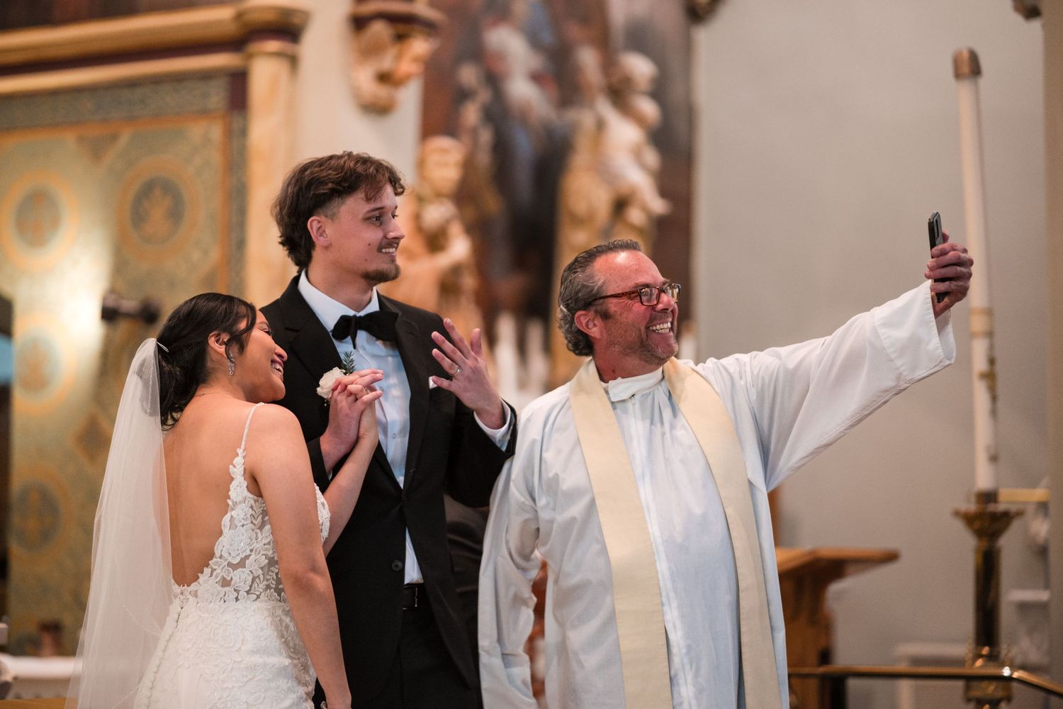 A celebratory moment during a wedding ceremony as the officiant raises his hand in blessing.