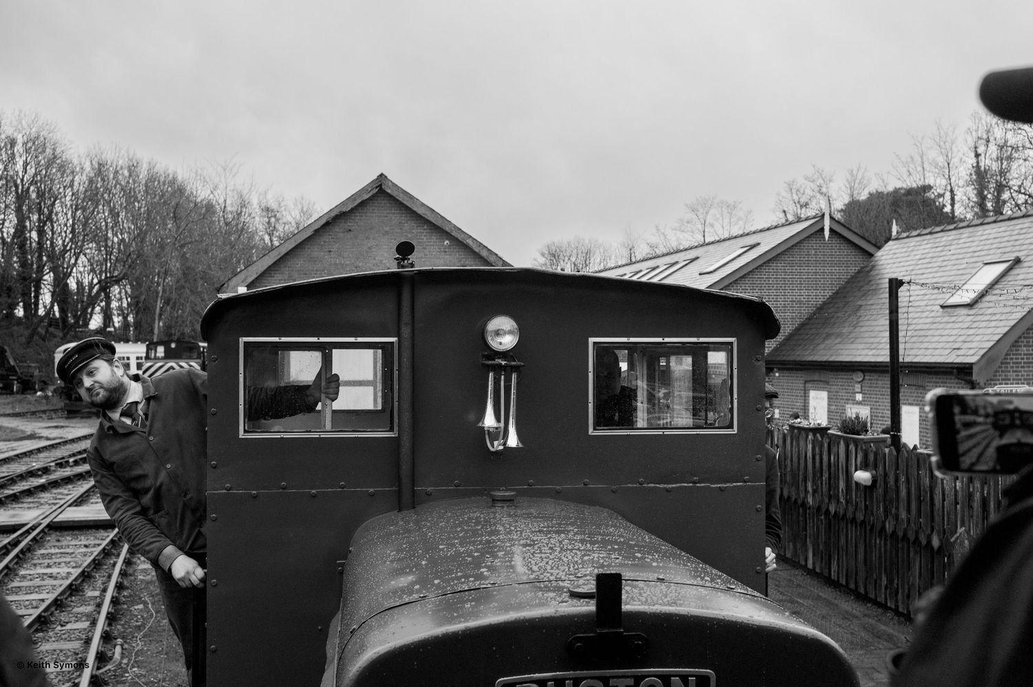 Black and white view from a train cab showing a signal box and railway tracks in the foreground.
