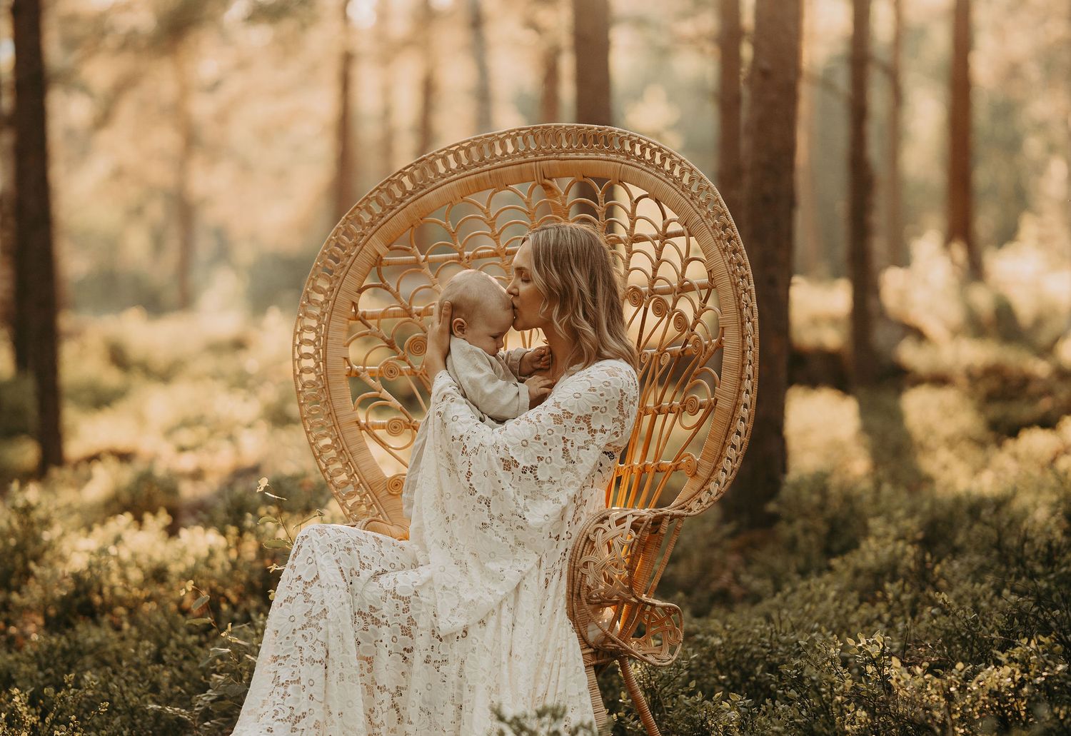A vintage peacock chair sits in a sunlit forest clearing with delicate white lace details catching the warm golden light.