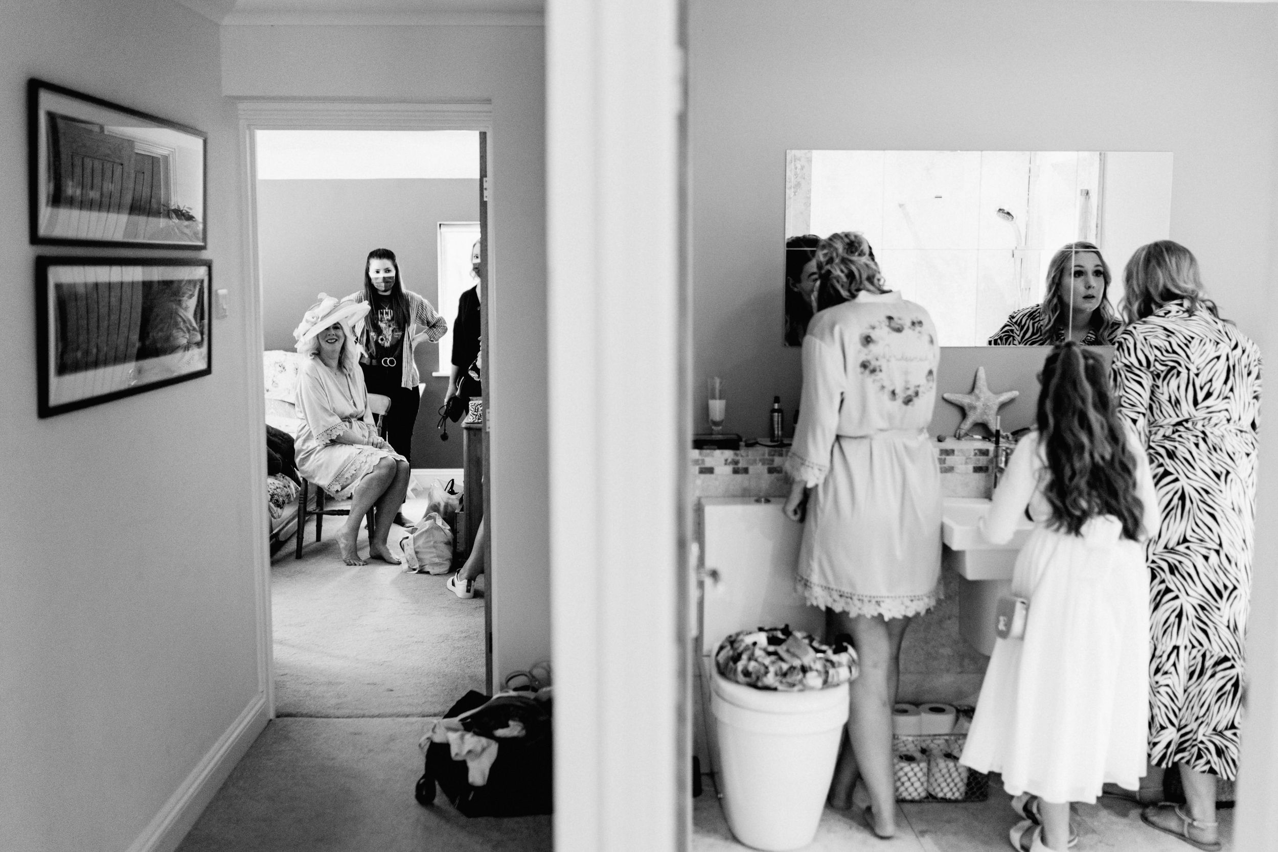 A black and white split view photograph shows two rooms in a home with people getting ready for a special occasion.